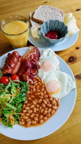 two plates of breakfast food on a wooden table at The Perfect Stop - Aurora Lodge in Lødingen