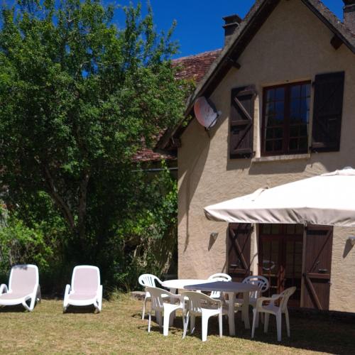 a group of chairs and tables and an umbrella at CHATEAU DE LACOMTE COUNTRY CLUB in Carlucet