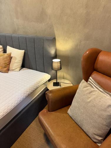 a hotel room with a bed and a chair at Tree Top Hill - The Old Station House - Båstad Holiday Apartments in Båstad
