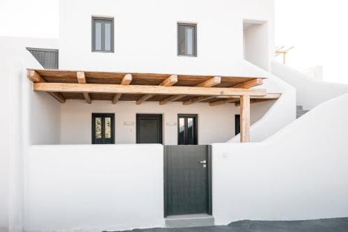a white house with a black door at Villa Libertad in Imerovigli