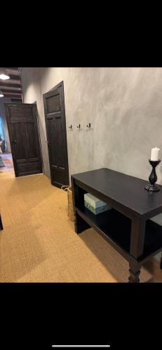 a living room with two doors and a table at Tree Top Hill - The Old Station House - Båstad Holiday Apartments in Båstad
