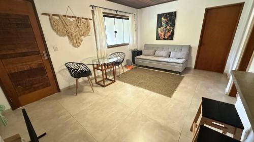 a living room with a table and a couch at Pousada Canto da Nascente in Monte Verde