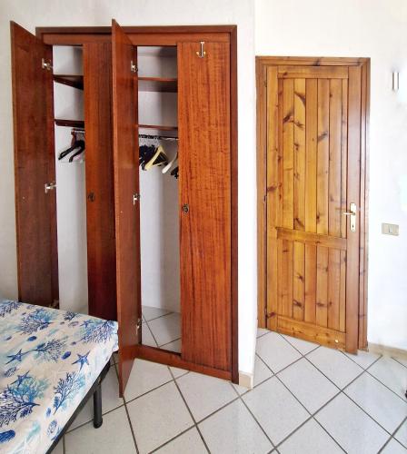 a room with two wooden doors and a closet at Holiday Vibes Relax in Quartu SantʼElena