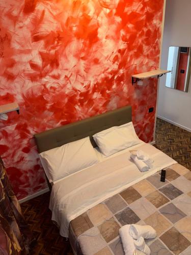 a bedroom with a bed with a red wall at Madonna dell'ancora in Sassuolo