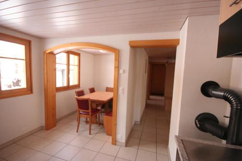 a kitchen and dining room with a table and a room at Chalet Galmihorn in Reckingen - Gluringen