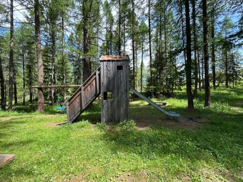 an old wooden playground in a field with trees at Chalet Galmihorn in Reckingen - Gluringen