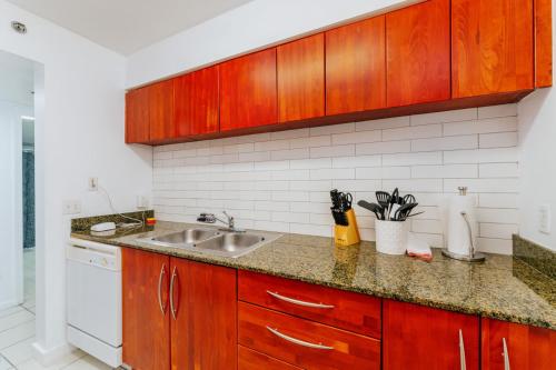 una cucina con mobili in legno e un lavello di Fantastic APT Brickell a Miami