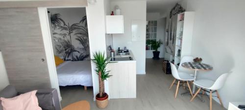 eine Küche und ein Schlafzimmer mit einem Bett und einem Tisch in der Unterkunft Appartement Le doux Viking, balcon & parking privé proche Zénith Caen in Caen