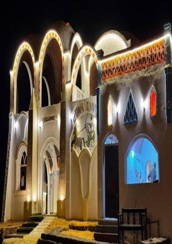 a building with lights on the side of it at Zena Toma Nubian Guest House in Aswan