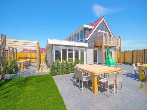 a patio with a table and chairs and a building at Callantsoog Group getaway Beach in Callantsoog