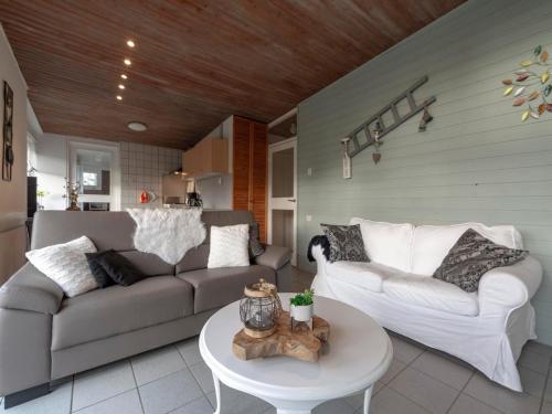 a living room with two couches and a table at Holiday Home Sint Maartenszee near Beach in Sint Maartenszee