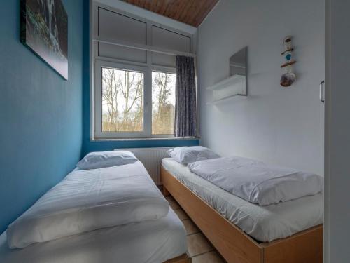 two beds in a room with a window at Holiday Home Sint Maartenszee near Beach in Sint Maartenszee