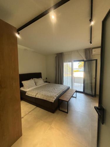 a bedroom with a large bed and a window at Five shades of blue in Vourvourou