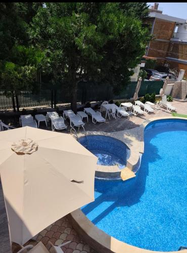 a pool with a table and chairs next to a building at Bo's place in St. St. Constantine and Helena