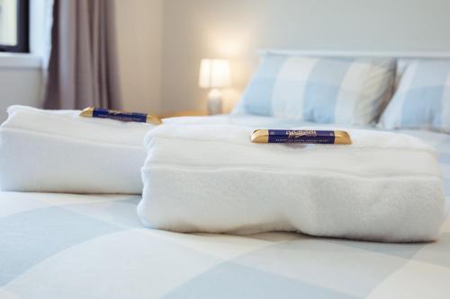 Hay dos toallas blancas encima de una cama. en Memorial Crescent Retreat - 4 bedroom family home, en Methven