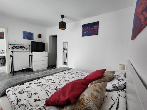 een slaapkamer met een bed met rode kussens en een televisie bij Rose 8 Bled in Bled