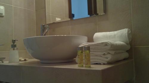 Villa Del Lago Boutique Hotel في كاستوريا: حمام مع حوض استحمام ومناشف على منضدة