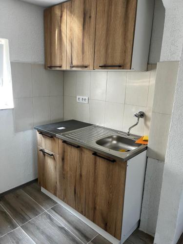 a small kitchen with a sink and wooden cabinets at Vila FiDa in Gornja Toplica
