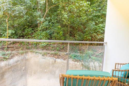 two chairs sitting on a balcony looking out a window at Playa Mantas CAMA QUEEN A-C 400MB in Tarcoles