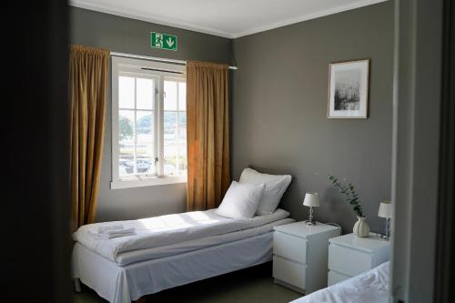 a small bedroom with a bed and a window at Hald Bed and Breakfast in Mandal