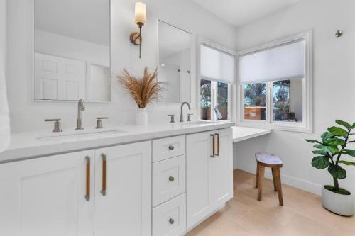 un bagno bianco con due lavandini e una pianta in vaso di Stunning 3BR Capo Beach Home with Ocean Views a Dana Point