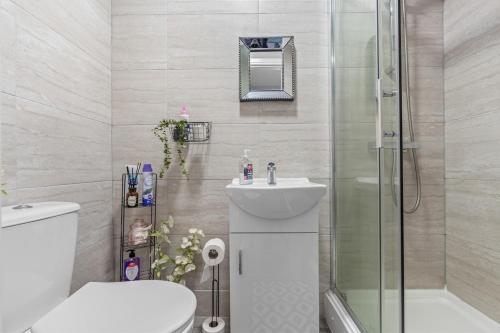 een badkamer met een douche, een toilet en een wastafel bij 15 Stylish Digbeth private Studio Apt City Centre in Birmingham