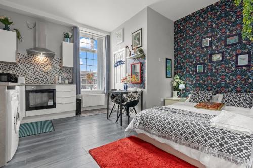 een slaapkamer met een bed en een keuken met een tafel bij 15 Stylish Digbeth private Studio Apt City Centre in Birmingham