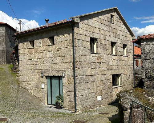 a stone building with a door on the side of it at Casa da Fonte, Monte in Terras de Bouro