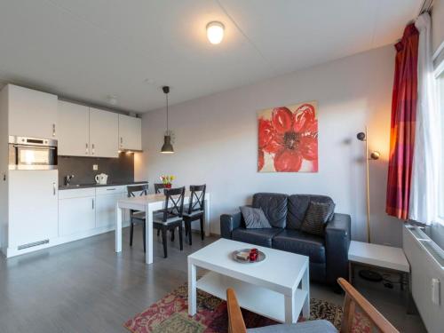 a living room with a couch and a table at Apartment by Dutch Dunes with Sea Views in Callantsoog