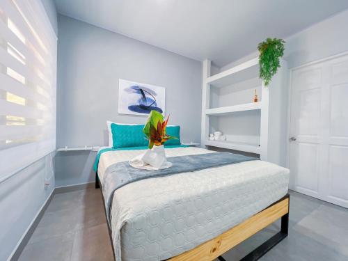 ein Schlafzimmer mit einem Bett mit einer Pflanze darauf in der Unterkunft Forest apartments studio F1, walking to the beach in Jacó