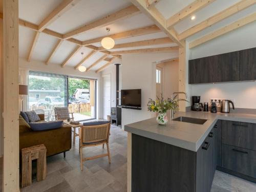 an open kitchen and living room with a couch at Attractive home with terrace in Callantsoog