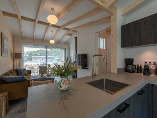 a kitchen with a sink and a living room at Attractive home with terrace in Callantsoog