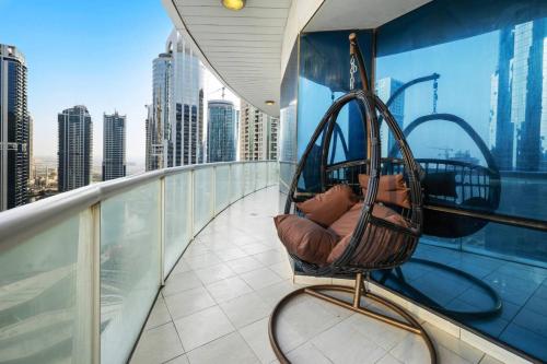 a chair on a balcony with a view of a city at Elegant Haven and Spacious 2BR in Lake Terrace in Dubai