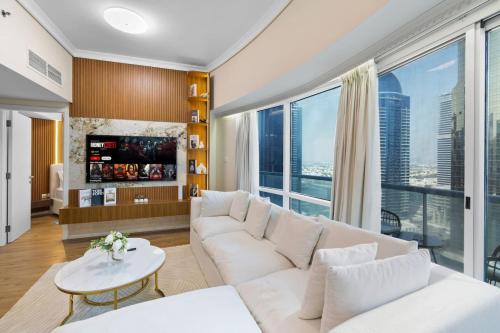 a living room with a white couch and a large window at Elegant Haven and Spacious 2BR in Lake Terrace in Dubai