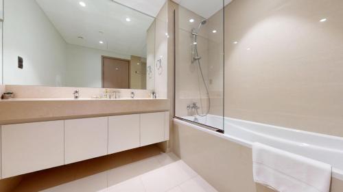 a bathroom with a shower and a sink and a tub at Vacationer I Luxury 2 Bedroom I Burj Khalifa View I Downtown I Free Gym, Pool, Parking & Wi-Fi in Dubai