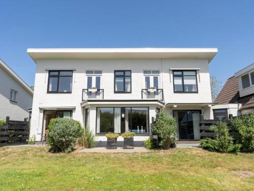 a large white house with black windows at Apartment in De Koog near Texel Beach in De Koog