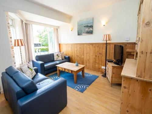 a living room with a blue couch and a table at Apartment in De Koog near Texel Beach in De Koog