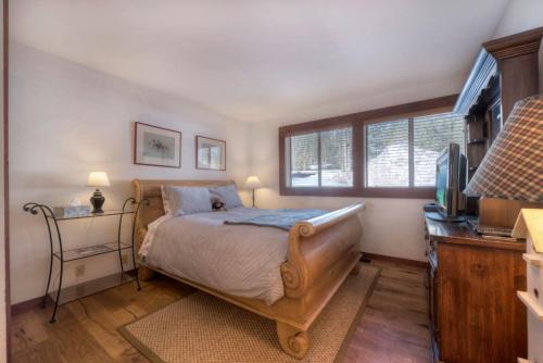 ein Schlafzimmer mit einem Bett und einem Fernseher darin in der Unterkunft Serene Condo by Palisades Base and Golf Course in Olympic Valley