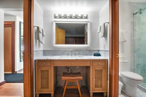 ein Badezimmer mit Waschbecken, Toilette und Spiegel in der Unterkunft Serene Condo by Palisades Base and Golf Course in Olympic Valley