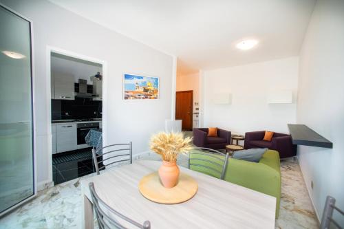 a dining room and living room with a vase on a table at Savona Sea House Apartment with parking in Savona