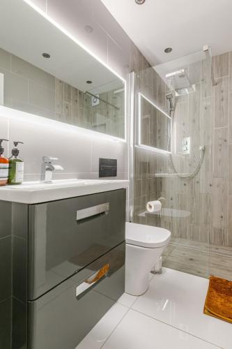 a bathroom with a sink and a toilet and a shower at Seafront townhouse in Sandgate in Sandgate
