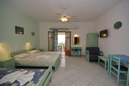 a bedroom with two beds and a table and chairs at Myriam Studios in Patitiri