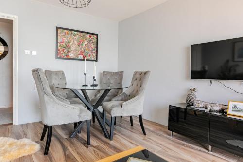a dining room with a table and chairs and a tv at Seafront townhouse in Sandgate in Sandgate