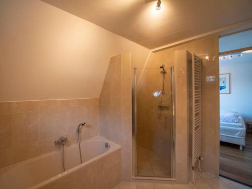 a bathroom with a shower and a bath tub at Penthouse Duinerei by the sea with sauna in Callantsoog