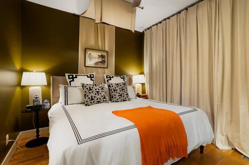 a bedroom with a bed with an orange blanket on it at Million Dollar Rooftop MTN Views -2 King Beds-DT Golden in Golden