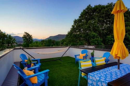 a patio with chairs and a table and a umbrella at Million Dollar Rooftop MTN Views -2 King Beds-DT Golden in Golden