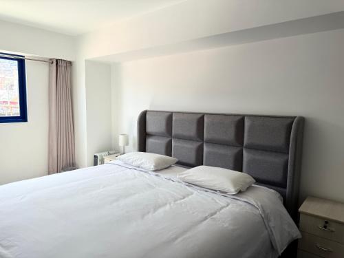 a bedroom with a large bed with a large headboard at SAM Apartment Cusco in Cusco