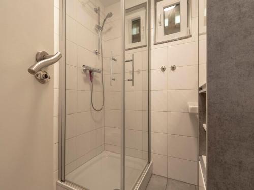 a shower with a glass door in a bathroom at Spacious Duo by the Dunes in Sint Maartenszee