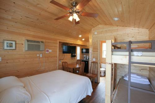 1 dormitorio con 1 cama y ventilador de techo en Lake Conroe Queen Studio Cabin 5, en Willis
