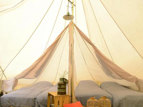 a tent with two beds in a room at Tent Lodge with Private Kitchen and Bathroom in Callantsoog